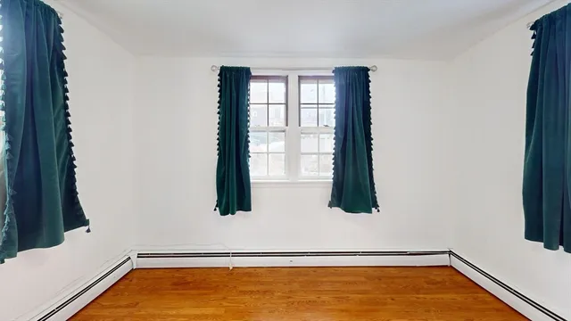 a room with a wooden floor and chandelier