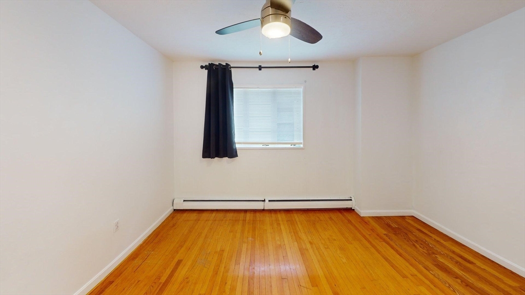 78 Fremont Street, Unit 78 Somerville, MA 02145 - Photo 21 of 30 a room with a wooden floor and chandelier