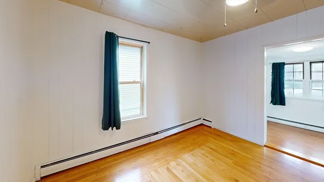 a view of an empty room with wooden floor