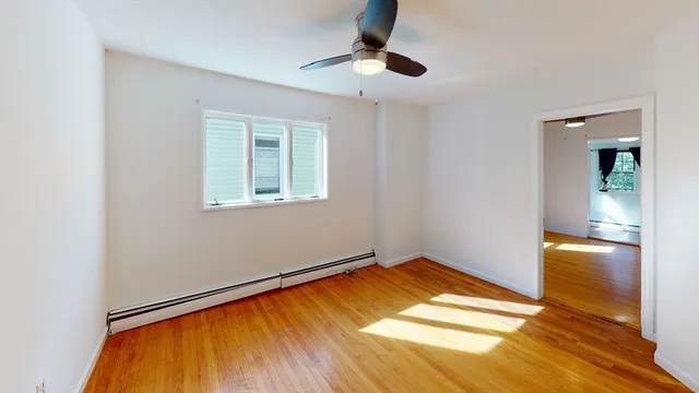 a view of empty room with wooden floor