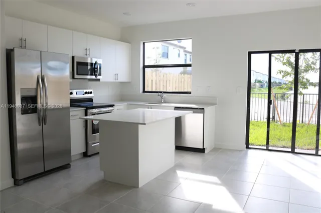 a kitchen with stainless steel appliances granite countertop a stove a refrigerator and a microwave