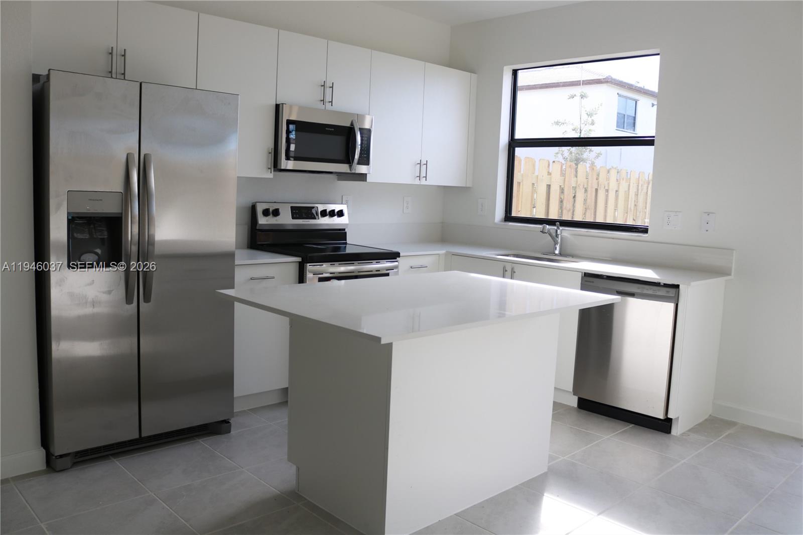 23040 Southwest 99th Court Cutler Bay, FL 33190 - Photo 2 of 23 a kitchen with stainless steel appliances granite countertop a refrigerator a stove a sink and a window