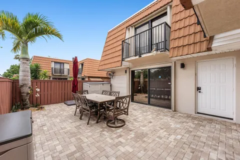 a view of a house with backyard and sitting area