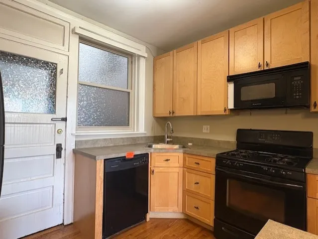 a kitchen with cabinets stainless steel appliances and a window