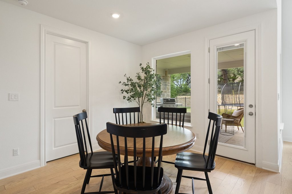 365 Pear Tree Lane Austin, TX 78737 - Photo 18 of 39 a view of a dining room with furniture and wooden floor