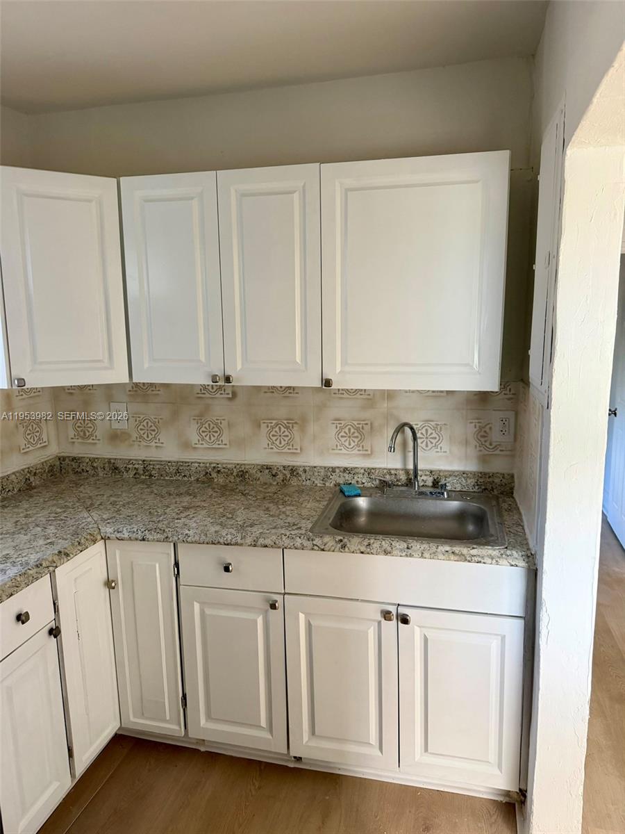 413 Northwest 63rd Street Miami, FL 33150 - Photo 32 of 55 a kitchen with granite countertop white cabinets and sink
