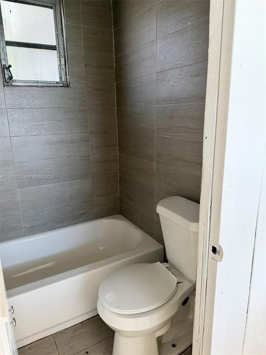 413 Northwest 63rd Street Miami, FL 33150 - Photo 47 of 55 a bathroom with a toilet and bathtub
