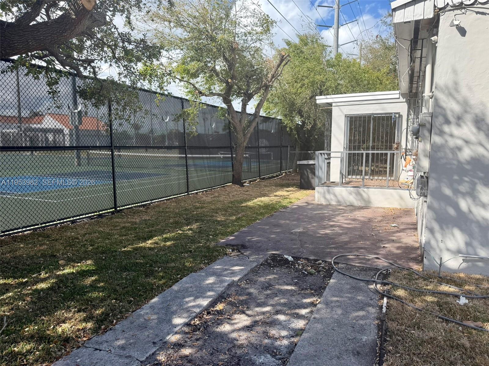413 Northwest 63rd Street Miami, FL 33150 - Photo 7 of 55 a view of a backyard with large trees and wooden fence