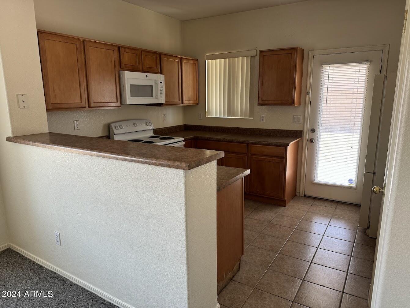9401 West Berkeley Road Phoenix, AZ 85037 - Photo 4 of 27 a kitchen with stainless steel appliances granite countertop a stove a sink and a microwave
