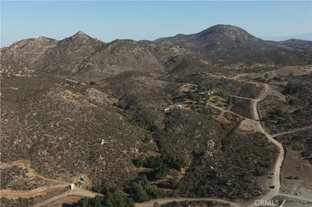 a view of a dry yard with trees