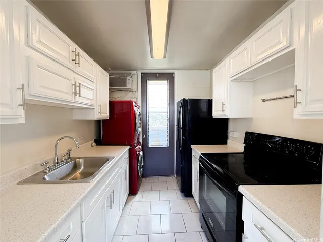 a kitchen with stainless steel appliances a sink a refrigerator and a cabinets