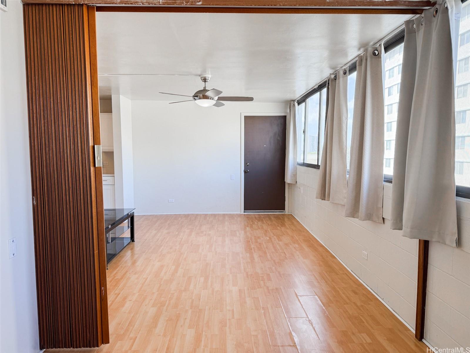 1134 Kinau Street, Unit 607 Honolulu, HI 96814 - Photo 5 of 10 a view of an empty room with wooden floor and a window