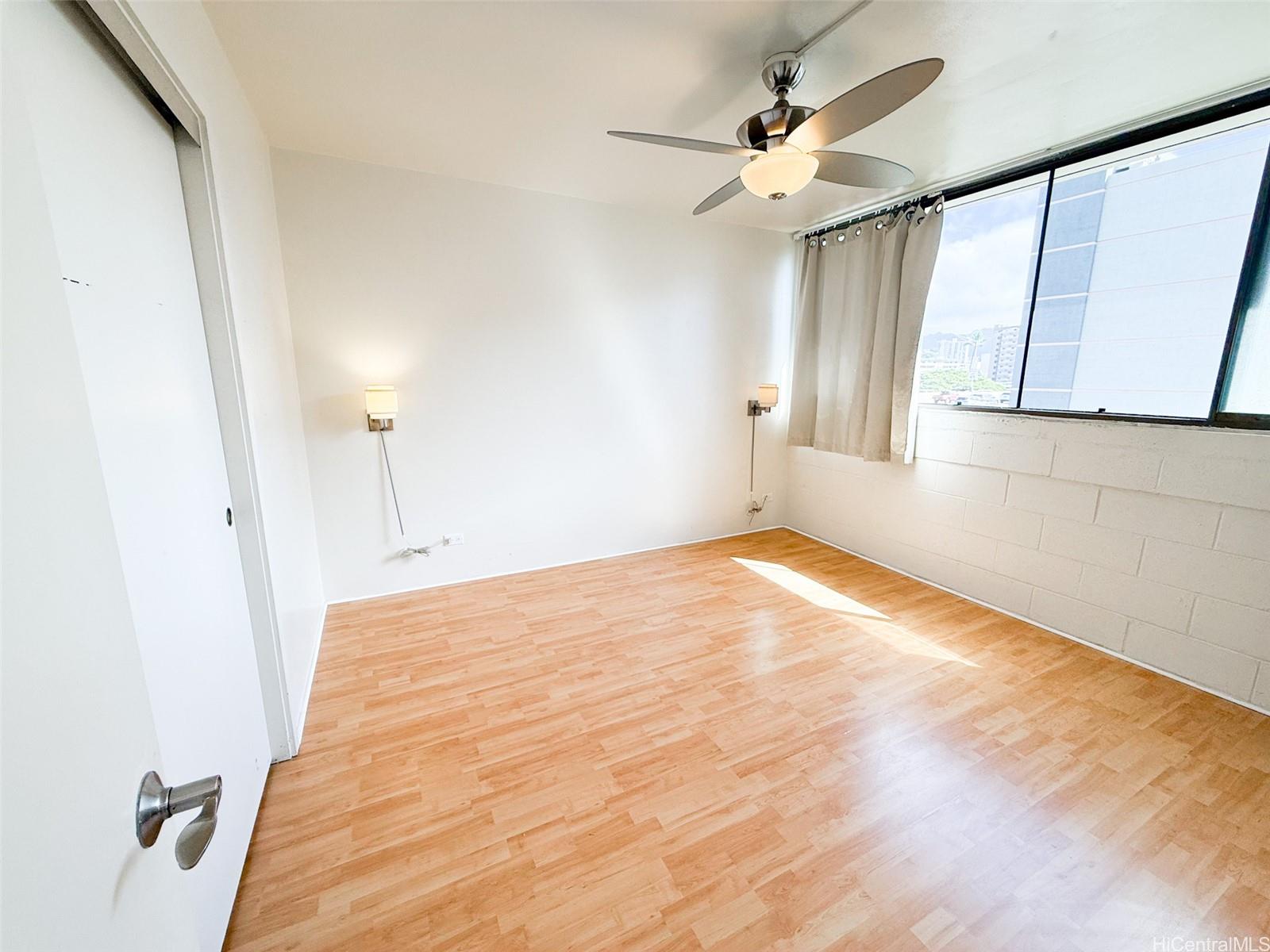 1134 Kinau Street, Unit 607 Honolulu, HI 96814 - Photo 6 of 10 a view of empty room with wooden floor and fan