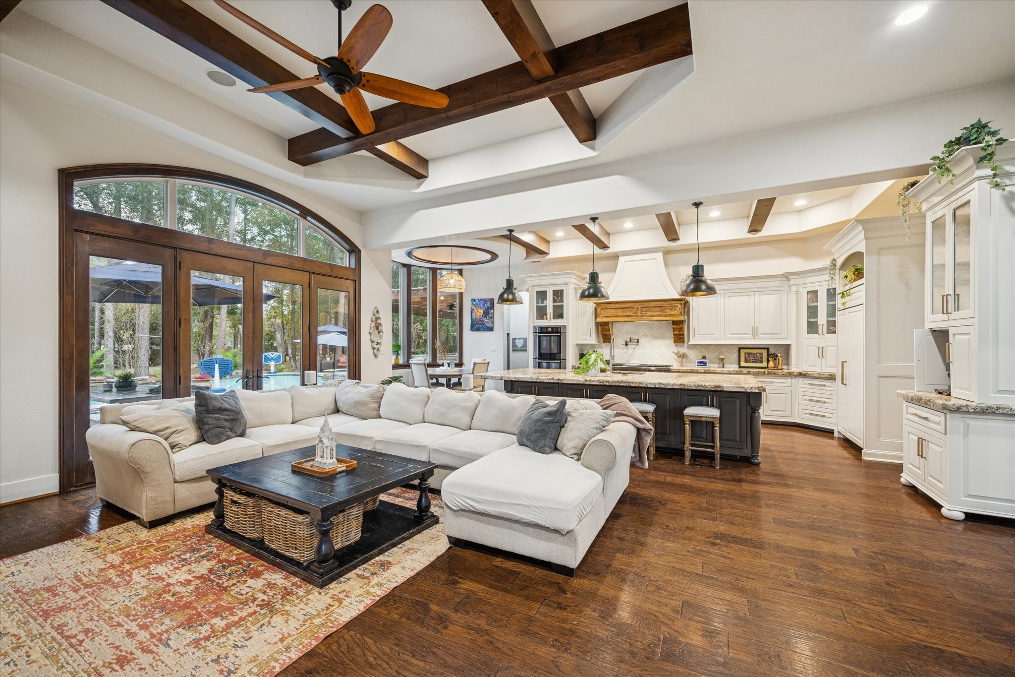 Step inside to a light-filled, open-concept living space where rich hardwood floors, exposed ceiling beams, and refined architectural details immediately set the tone for the warmth and sophistication found throughout the home.