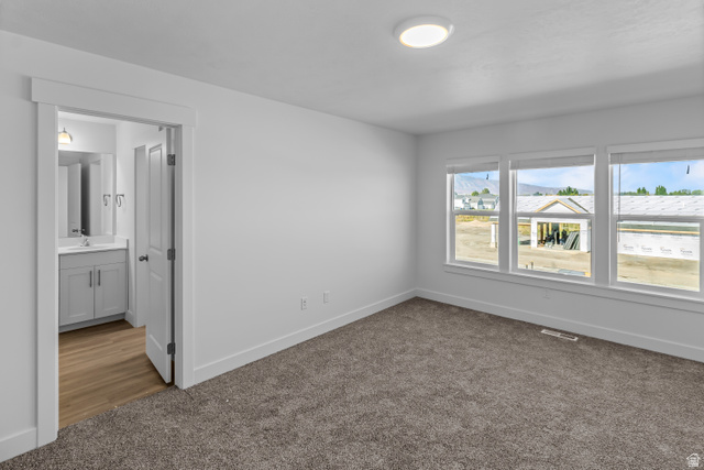 2995 South 265th Street West, Unit 752 Logan, UT 84321 - Photo 17 of 21 Plush carpeted room featuring a white ceiling light fixture, a trio of windows, and white baseboards