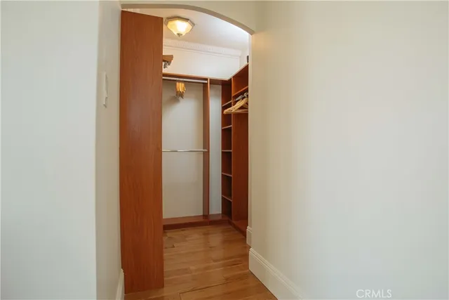 a view of a hallway with wooden floor and closet