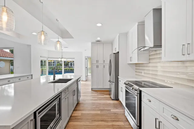 a kitchen with stainless steel appliances a sink stove and refrigerator