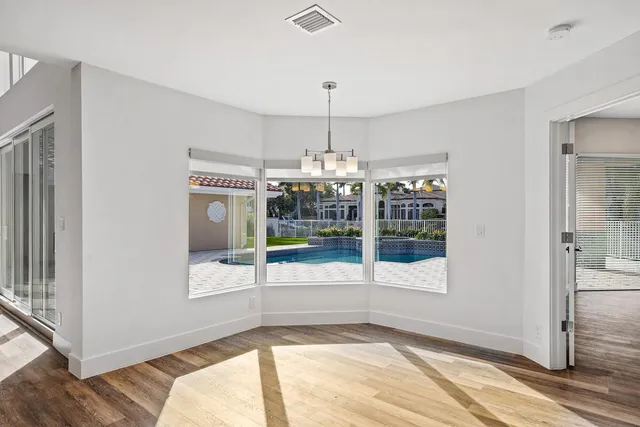 a view of an empty room wooden floor and a window