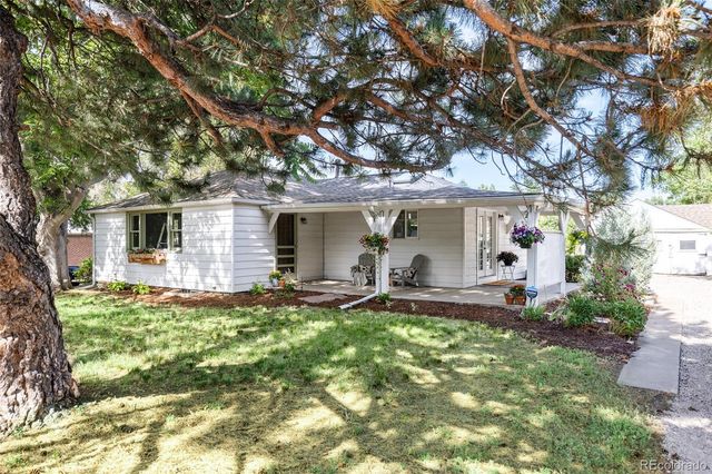 a front view of a house with a yard and trees