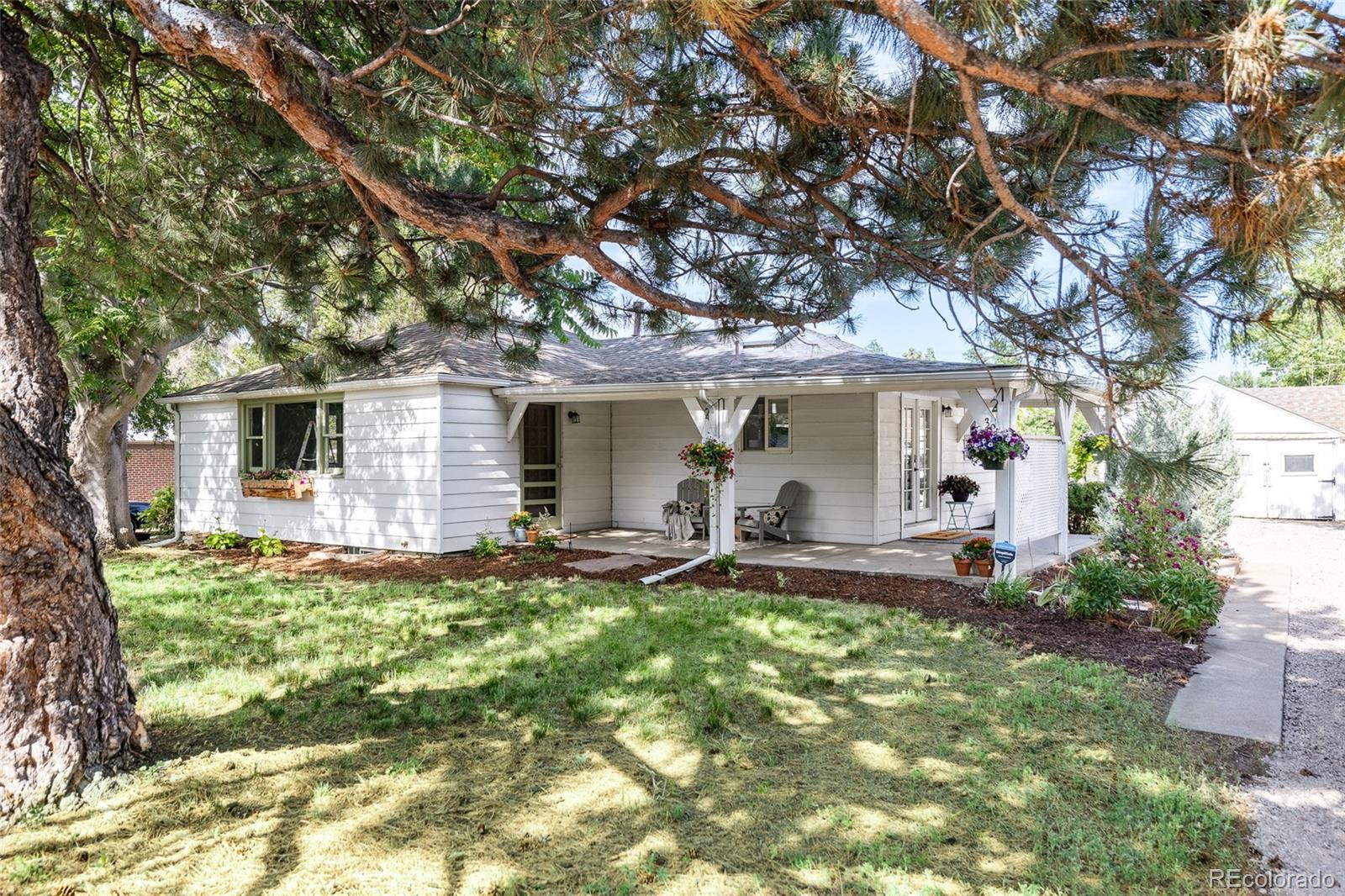 3940 Quay Street Wheat Ridge, CO 80033 - Photo 3 of 28 a front view of a house with a yard and trees