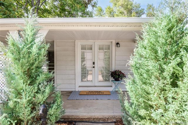 a view of a small house with potted plants