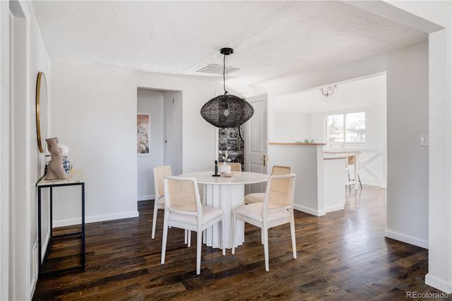 a dining room with furniture wooden floor a rug and a chandelier