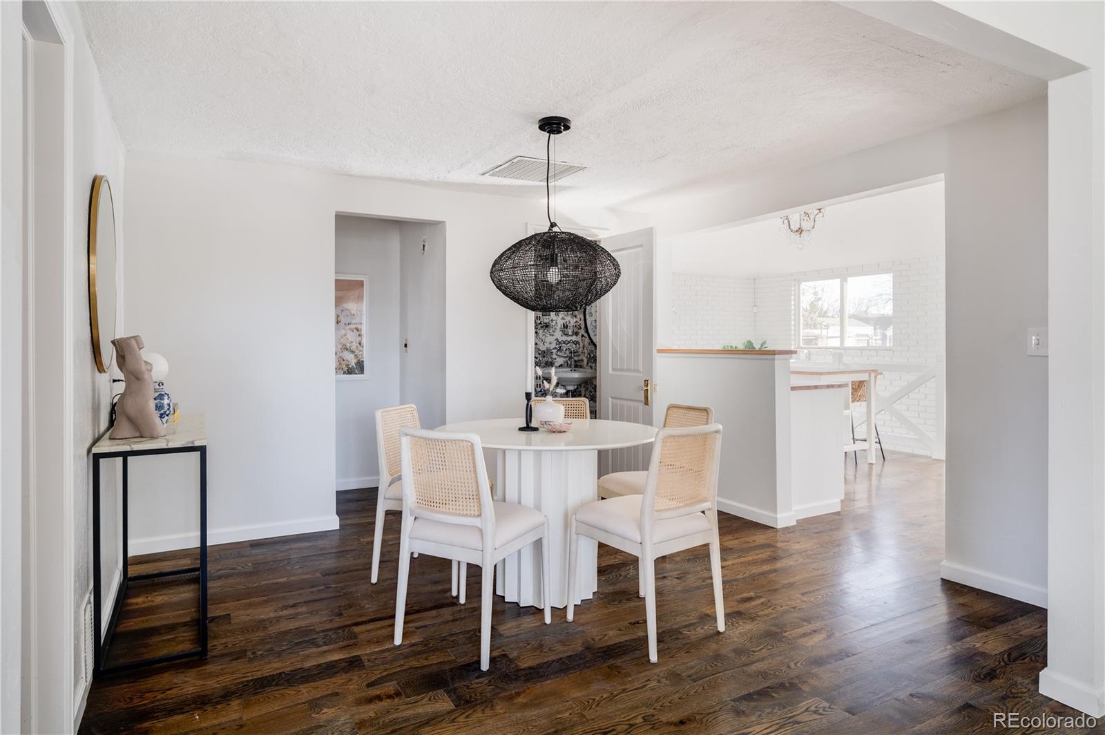 3940 Quay Street Wheat Ridge, CO 80033 - Photo 8 of 28 a dining room with furniture wooden floor a rug and a chandelier