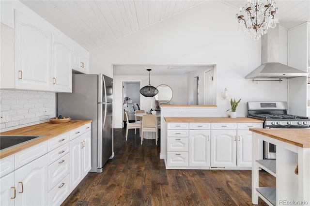 a kitchen with stainless steel appliances a table chairs and a chandelier