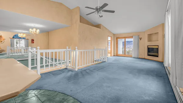 a view of a hallway with stairs and a living room area