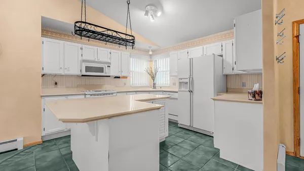 a kitchen with kitchen island a sink stainless steel appliances and white cabinets