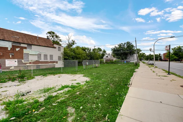 a view of a street with a view of a house with a yard