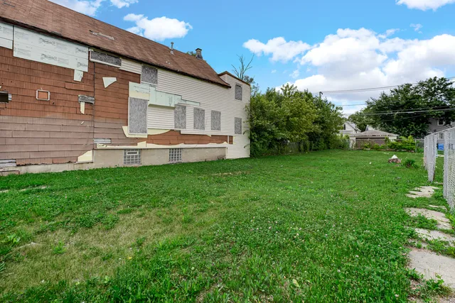 a view of a house with a yard and sitting area