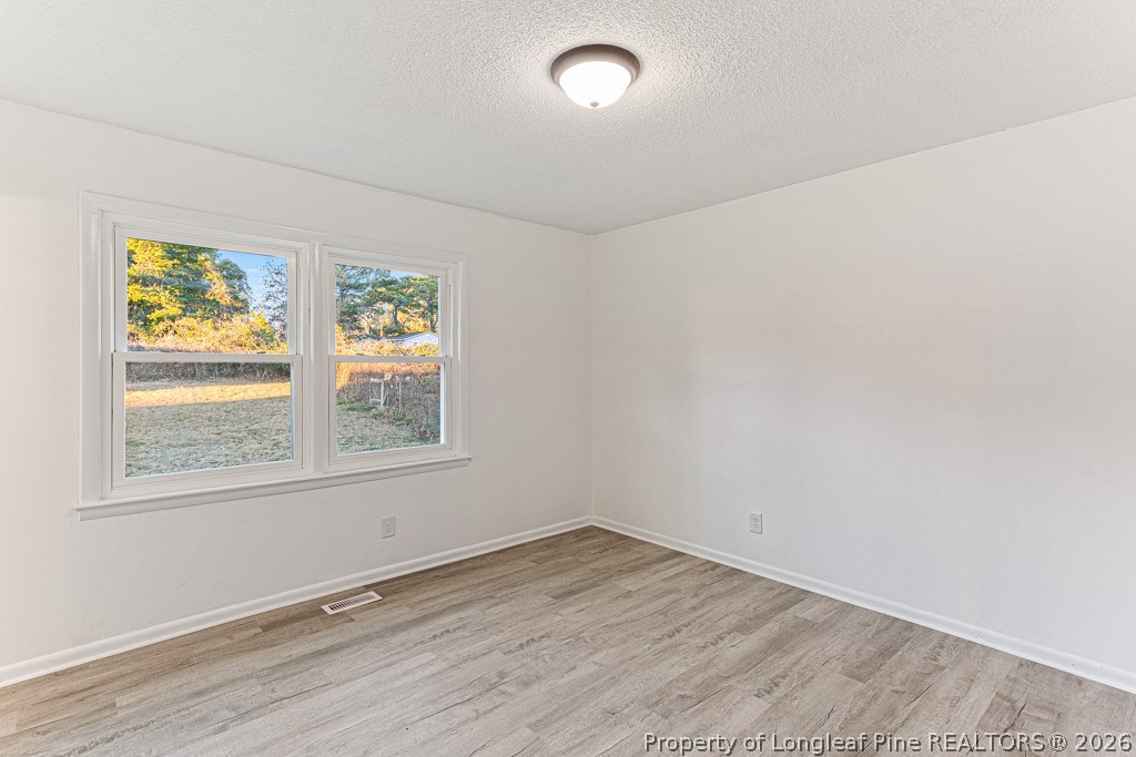 922 Rancho Drive Fayetteville, NC 28303 - Photo 19 of 21 an empty room with wooden floor and window