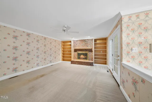 a view of an empty room with a fireplace and a window