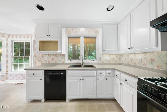 a kitchen with white cabinets and a stove