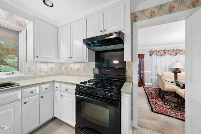 a kitchen with white cabinets and appliances