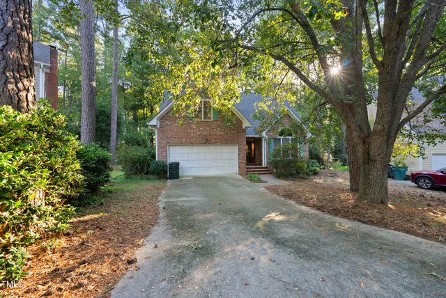 a front view of a house with a yard and trees