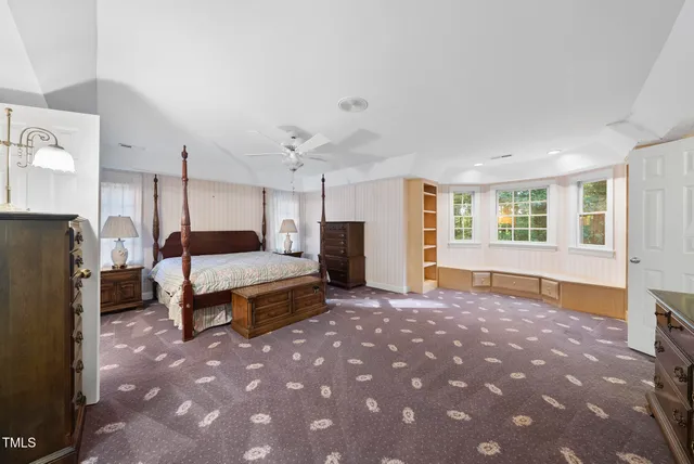 a spacious bedroom with a bed a table and chair