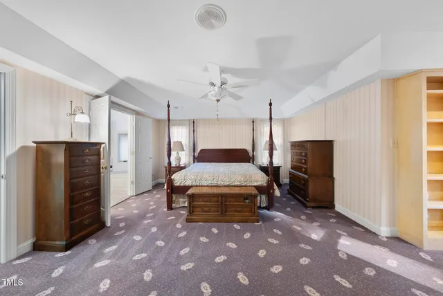 a spacious bedroom with a bed and a chandelier
