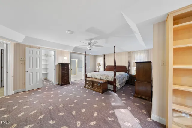 a spacious bedroom with a bed a table and chairs