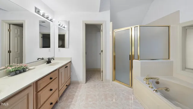 a spacious bathroom with a tub sink and mirror