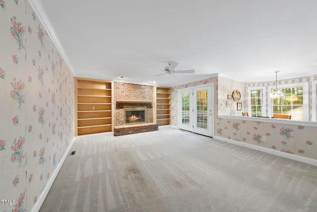 a view of an empty room with a fireplace and a window