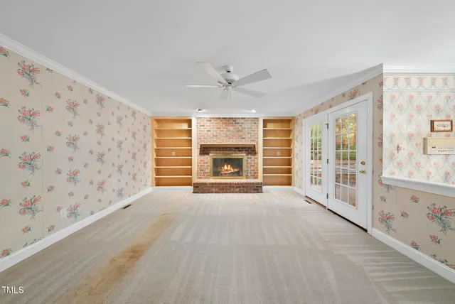 a view of an empty room with a fireplace and a window