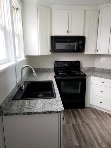 a kitchen with granite countertop a stove and a sink