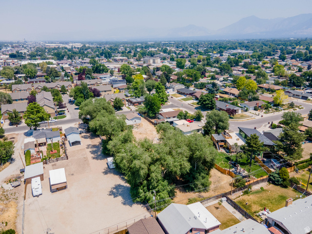 120 Cox Lane Midvale, UT 84047 - Photo 6 of 13 Expansive lot with mature trees, surrounded by residential properties, with distant mountains forming a natural backdrop