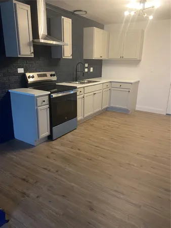 a kitchen with stainless steel appliances granite countertop a sink stove and cabinets