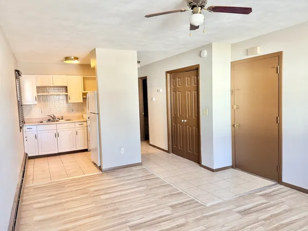 a view of a kitchen with a sink cabinet and a refrigerator