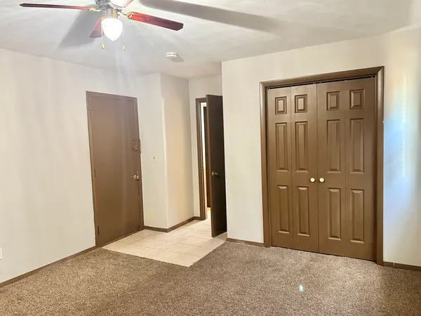 an empty room with windows and closet area