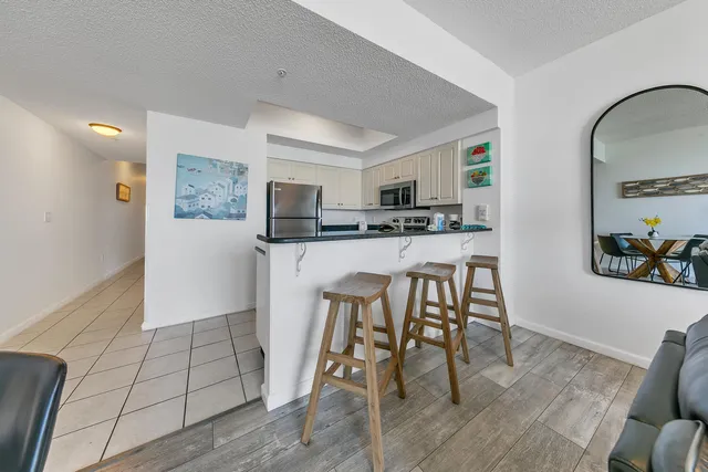 a kitchen with stainless steel appliances a dining table chairs and granite counter tops