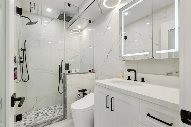 a bathroom with a sink a toilet and shower